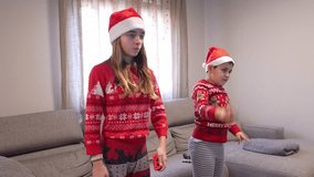Happy brother and sister wearing santa hats and festive pajamas playing a new video game console received as a christmas gift in the living room - Powered by Shutterstock - Get 15% off with code: PIKWIZARD15