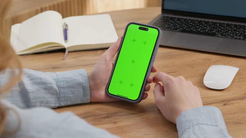 Woman sit use digital tech cell phone open green screen mock up. Hand scroll iphone web site swipe unlock. Girl hold mobile closeup. Turn on chroma key page Cozy home background. Online app copy space