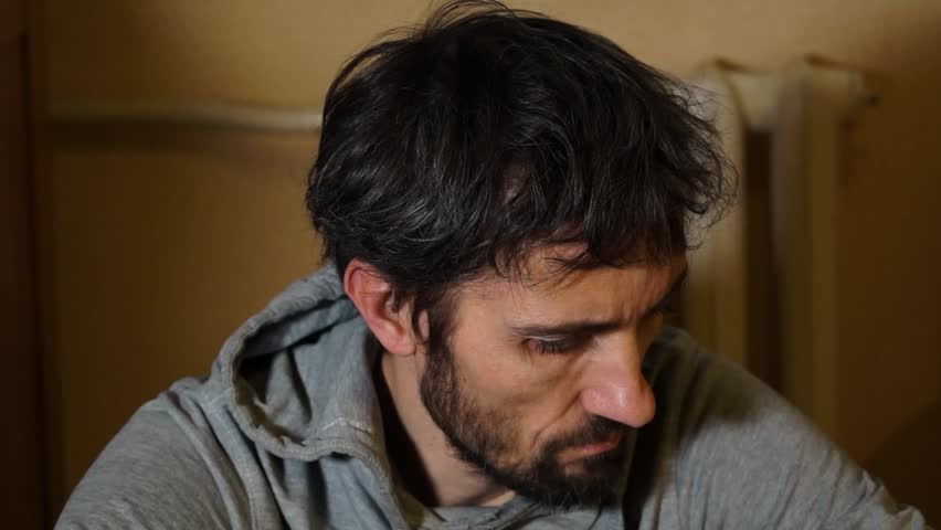 A worried man is sitting on the floor. Depression Drug addiction Alcohol addiction Mental disorder. unemployment, despondency, loneliness, disappointment, decline, bad news