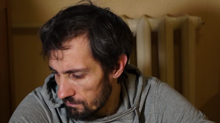 A worried man is sitting on the floor. Depression Drug addiction Alcohol addiction Mental disorder. unemployment, despondency, loneliness, disappointment, decline, bad news