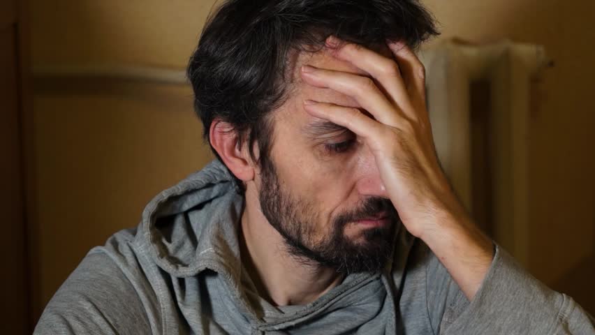 A worried man is sitting on the floor. Depression Drug addiction Alcohol addiction Mental disorder. unemployment, despondency, loneliness, disappointment, decline, bad news