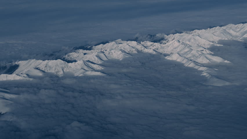 Transylvania’s Carpathian Mountains, with snowy peaks rising above a sea of clouds. Serene, remote, dramatic winter landscape in Romania.