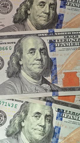 Vertical close-up: US hundred dollar bills are counted on a table, illustrating financial calculations, cash management, budgeting, wealth, monetary transactions, and banking concepts.