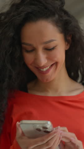 Happy Hispanic student girl walking university corridor smiling using smartphone female woman college high school hall walk go move to class education study laughing positive mobile phone social media