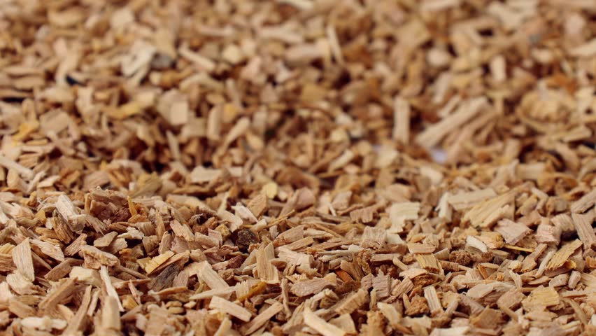 Wood alder smoking chips falling down close up