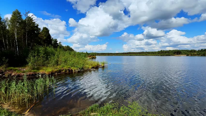 Breathtaking Tranquility: A Serene Lakeside View with Lush Greenery and Expansive Blue Sky Reflected in Calm Waters Under a Dramatic Cloudscape, Finland