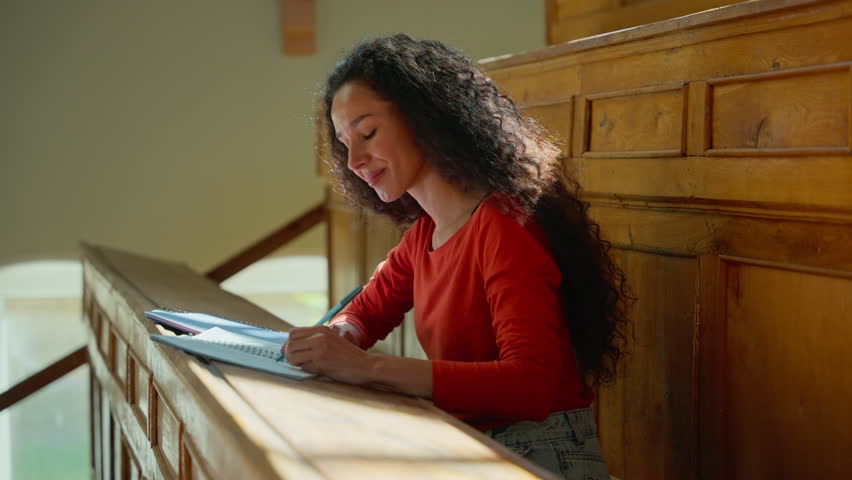 Pensive student girl listening in university auditorium writing notes thinking Hispanic woman listen teacher class lecture write information female studying learning course copybook college academy