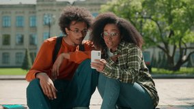 Two amazed multiracial students looking mobile phone excited good news outdoor shocked friends couple African American man guy male with woman girl female together online achieve win city university - Powered by Shutterstock - Get 15% off with code: PIKWIZARD15