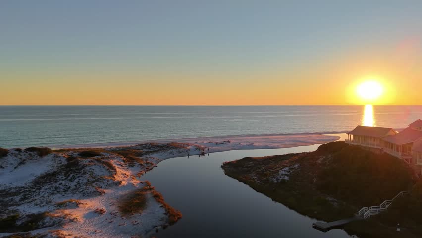 Drone orbit in romantic sunset glowing at Draper Lake endpoint meeting Gulf of Mexico, Old Florida Beach, Florida, USA