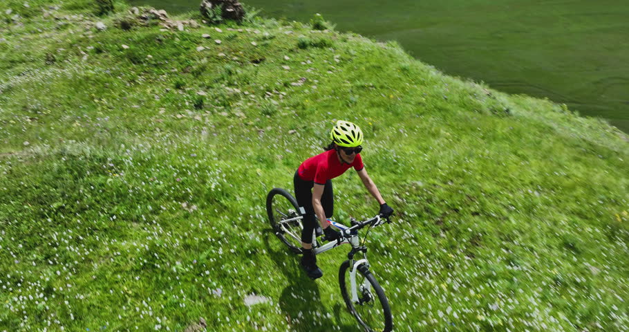 Riding mountain bike in the beautiful flowering grassland mountains