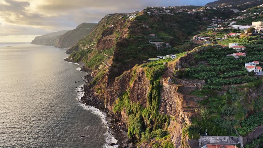 Aerial view of coastal cliffs and houses in Madeira Portugal during the late afternoon sunlight showcasing natural beauty