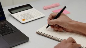 Close-up of hand writing 2026 in notebook with pen on desk with calculator and laptop. Concept of planning, budgeting, financial goals, new year strategy, productivity and personal development. - Powered by Shutterstock - Get 15% off with code: PIKWIZARD15