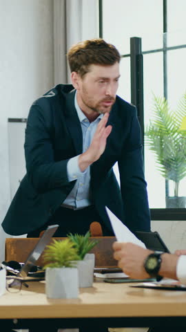 Frustrated stressed bearded boss quarreling alarmed multiethnic corporate coworkers during joint conference because they not diligently made their work with documents