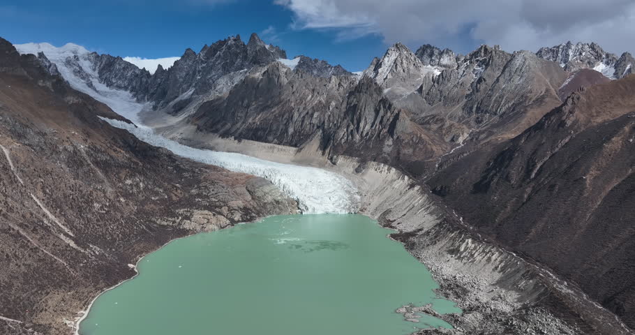 Beautiful high altitude hanging glacier and snow capped mountain with lake in Tibet, China