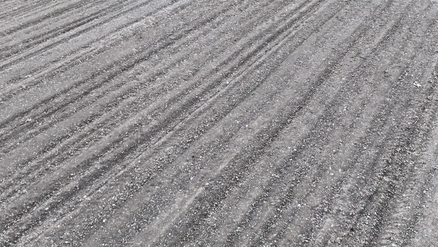 Wide angle aerial view of a plowed field with extensive soil furrows stretching towards the horizon representing the beginning of the agricultural cycle