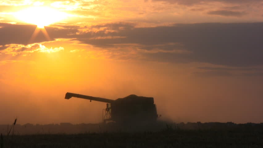 Harvester completes harvest. The engine stops working. Silhouette of the driver