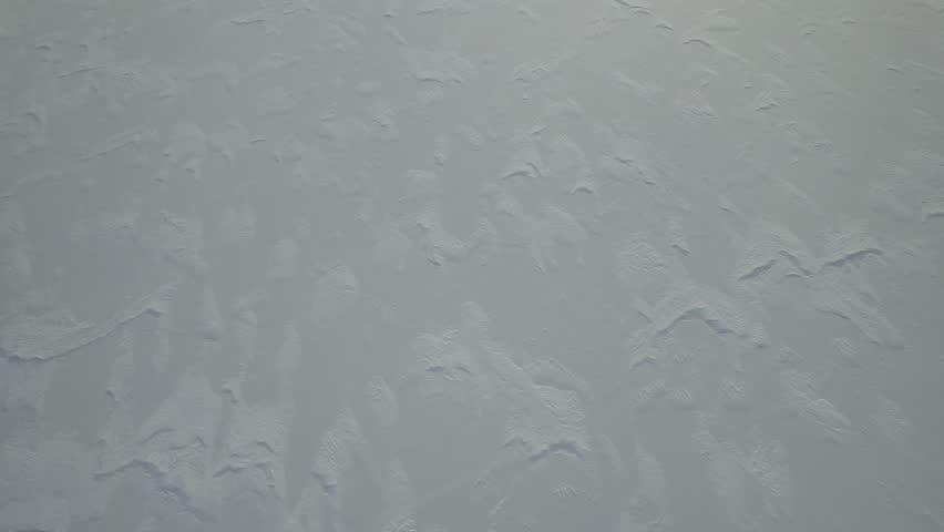 A dynamic aerial pans up from a snow-covered shore, frozen Kathleen Lake to reveal the majestic King