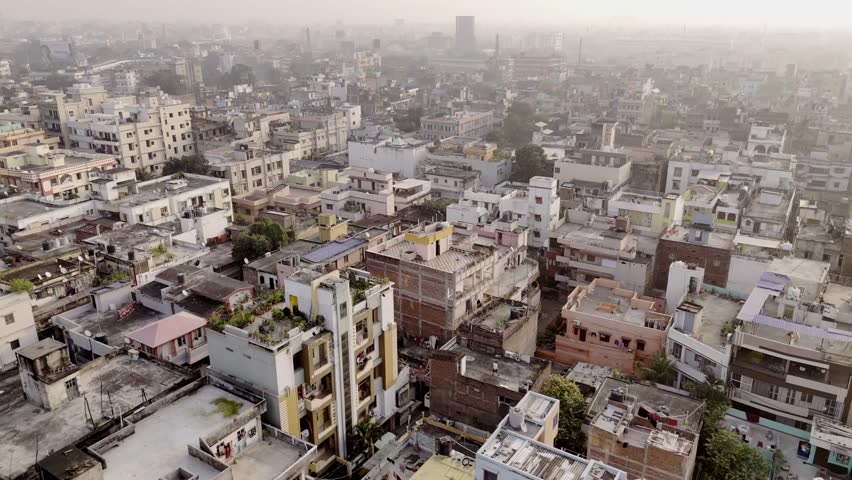 Tier 2 Patna city adjacent residential apartments under hazy environment due to air pollution, Karbigahiya Power grid in view at back, drone shot