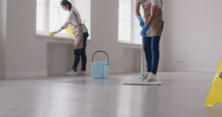 Janitorial team cleaning service industry working, professional people washing floor, window sill, cleaning building, office space, mopping, housekeeping job, yellow caution wet floor board standing