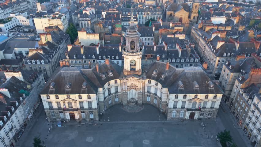 Drone pulling back above Rennes City Hall and its square at sunrise.