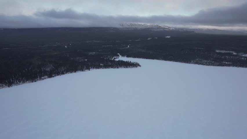 Cinematic flies forward from frozen surface of Kathleen Lake towards majestic King