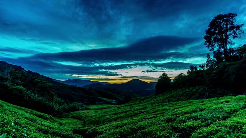 Lush Green Hills And Valley Under Cloudy Sky