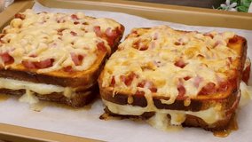 Hot grilled ham and cheese sandwich being lifted from a baking tray with melted cheese oozing - Powered by Shutterstock - Get 15% off with code: PIKWIZARD15