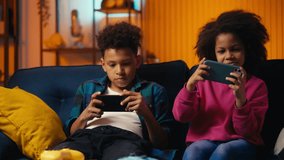 African American children playing mobile games on phones, ignoring conversation - Powered by Shutterstock - Get 15% off with code: PIKWIZARD15
