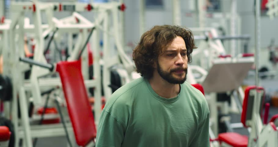 Seated dumbbell raises for the deltoid muscles. Deltoid workout with dumbbells. Slow motion 4k footage of a Caucasian man during gym workout.