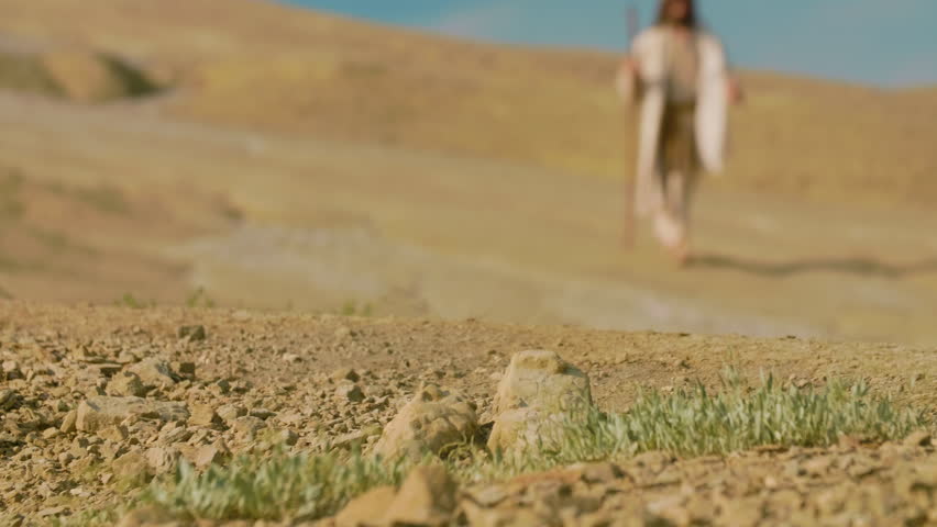 A lone Traveler in ancient-style clothing walks through a barren desert landscape, surrounded by sculpted sand formations and warm golden light. Cinematic scene evoking solitude, spirituality and timeless exploration. Slow motion shot