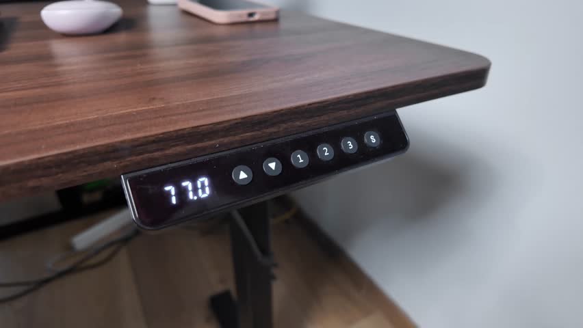 Detailed view of a modern standing desk's digital control panel displaying height 80.7 with programmable preset buttons, enhancing ergonomic comfort and daily productivity