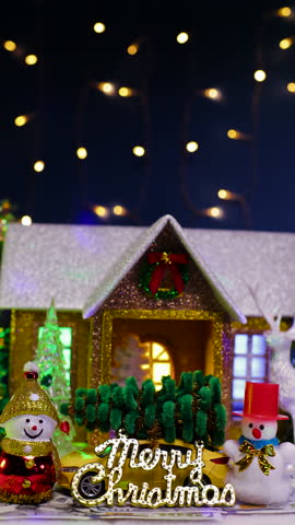 On a dark blue background with a flashing garland, a Christmas house with two snowmen and a yellow car with letters in front