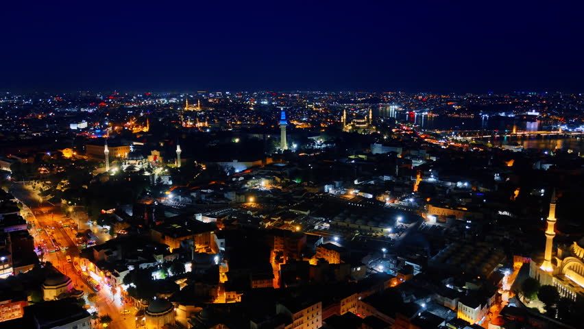 Flight over the night scenery of gorgeous Istanbul, Turkey. Beautifully illuminated panorama of the city.