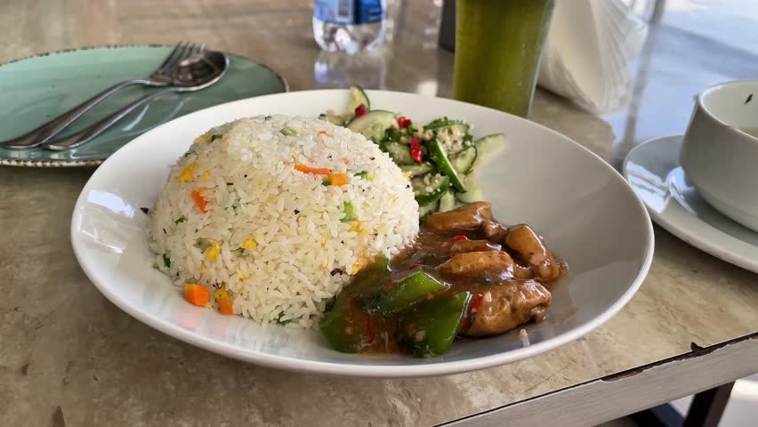 Fried rice with chicken, salad, and a drink.