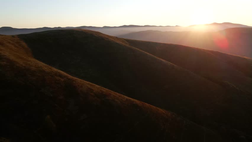 Sunrise light over rolling mountain ridges