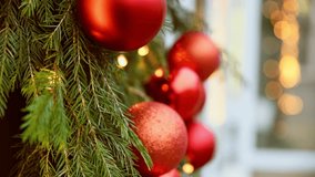 Festive red baubles hang on vibrant green pine garland decorated with warm string lights. Soft focus background highlights cozy holiday atmosphere and seasonal celebration - Powered by Shutterstock - Get 15% off with code: PIKWIZARD15