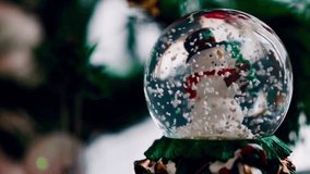 Close-up view of a Christmas snow globe with a snowman figure inside, surrounded by falling snowflakes and festive holiday decorations in soft blurred background.
 - Powered by Shutterstock - Get 15% off with code: PIKWIZARD15