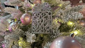 A delicate toy gift in silver and purple tones on a snow-covered branch of a New Year's tree with pink balls and warm lighting — a video for decorating holiday collections and designing greeting cards - Powered by Shutterstock - Get 15% off with code: PIKWIZARD15