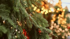 Evergreen pine branches adorned with small white fairy lights illuminated by warm golden bokeh in background, creating cozy and festive atmosphere - Powered by Shutterstock - Get 15% off with code: PIKWIZARD15