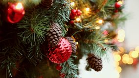 Festive christmas decoration on green pine branches features shiny red baubles and natural pine cones illuminated by soft warm fairy lights. Bokeh light effects create cozy holiday ambiance - Powered by Shutterstock - Get 15% off with code: PIKWIZARD15