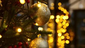 Festive christmas tree adorned with sparkling gold bauble and illuminated by warm yellow fairy lights. Soft bokeh lighting in background creates cozy holiday atmosphere - Powered by Shutterstock - Get 15% off with code: PIKWIZARD15