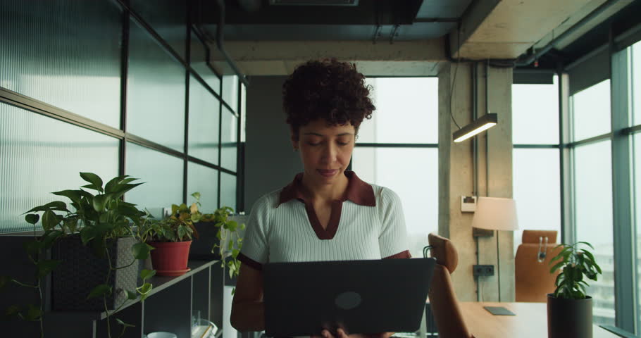 black content creator edits on laptop in creative office