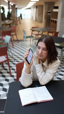 Vertical screen Artificial intelligence chats with a student as she shares campus news and university gossip smiling while discussing local stories with playful curiosity