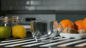 Hand pouring steaming lemon and ginger herbal tea into a transparent glass cup, soothing hot drink for wellness and home comfort concept - Powered by Shutterstock - Get 15% off with code: PIKWIZARD15