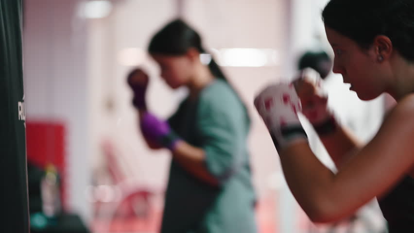Determined women boxing training at the gym