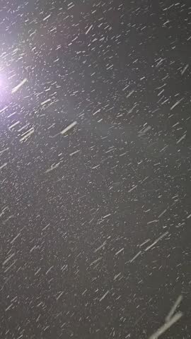 Illuminated Snow Falling in the Wintertime.