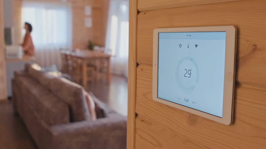 Medium close-up selective focus of a smart home climate control system app on a tablet, highlighting home automation, technology, and modern living in 4K.