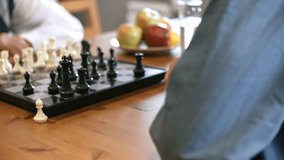 Unrecognizable young and senior men playing chess, highlighting strategy, cognitive skills, and intergenerational interaction in 4K. - Powered by Shutterstock - Get 15% off with code: PIKWIZARD15