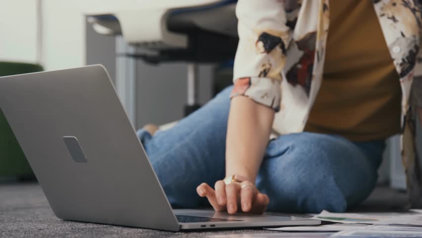 Young woman working on a laptop in a modern office, highlighting productivity, technology, business environment, and professional lifestyle.