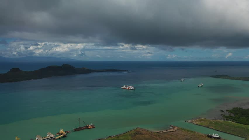 Aerial View of Coastal Port Area with Ships, Blue Ocean, Small Islands, and Green Farmland Landscape in Tropical Indonesia